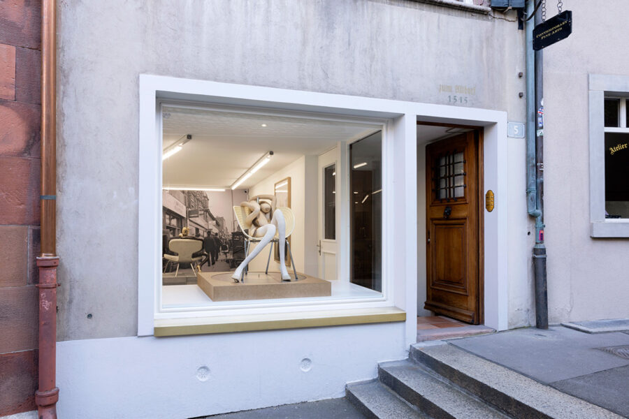 Storefront of a contemporary art gallery featuring a white abstract sculpture in the window.