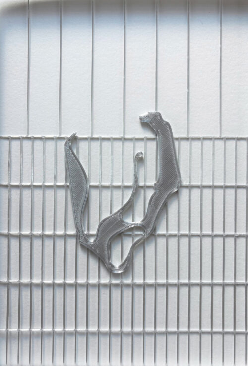 Ein transparentes, 3D-gedrucktes Kunststoffobjekt liegt auf einer gerillten weißen Oberfläche.