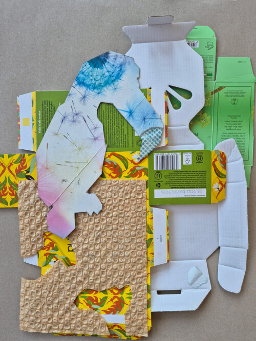 Verschiedene bunte Pappkarton-Reste und strukturierte Verpackungsmaterialien auf hellem Grund.