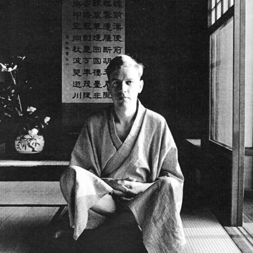 Schwarz-weiß-Foto eines Mannes in einem japanischen Kimono, der in einem traditionellen Raum sitzt.