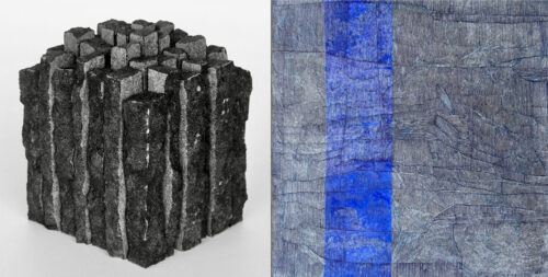 Eine schwarze, blockartige Skulptur neben einem abstrakten Gemälde mit blauem vertikalem Streifen.
