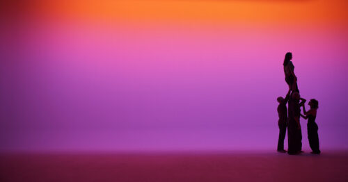 Silhouetten von vier Personen vor einem violett-orangefarbenen Hintergrund.