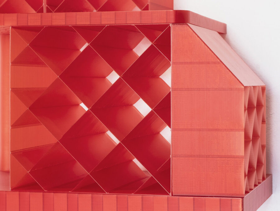 Nahaufnahme einer roten, geometrischen Gitterstruktur aus Kunststoff vor weißem Hintergrund.