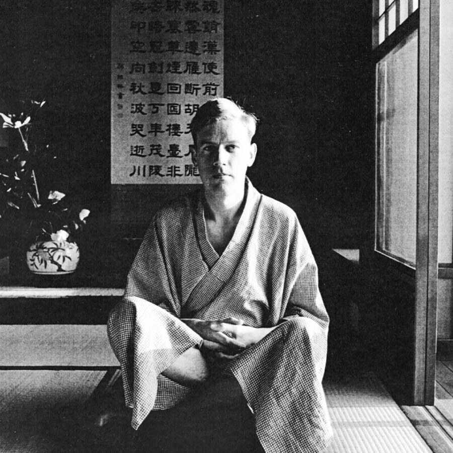 Schwarz-weiß-Foto eines Mannes in einem japanischen Kimono, der in einem traditionellen Raum sitzt.