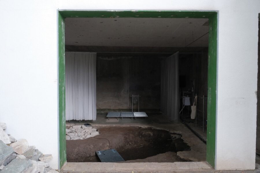 Blick durch eine Türöffnung auf eine archäologische Ausgrabungsstätte in einem Gebäude.