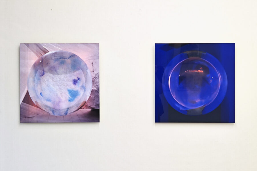 Zwei quadratische Bilder an einer weißen Wand zeigen abstrakte, leuchtend blaue Kugeln.