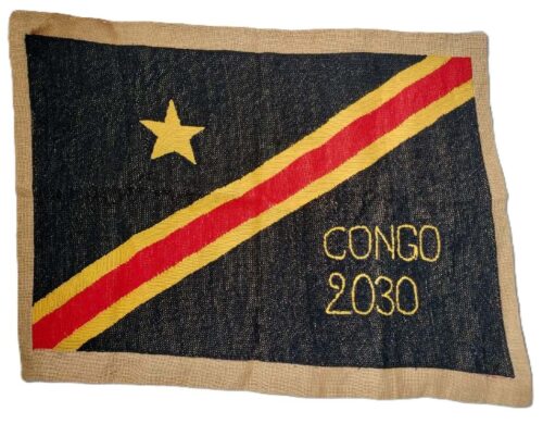Ein gewebtes Tuch in den Farben der Demokratischen Republik Kongo mit der Aufschrift Congo 2030.