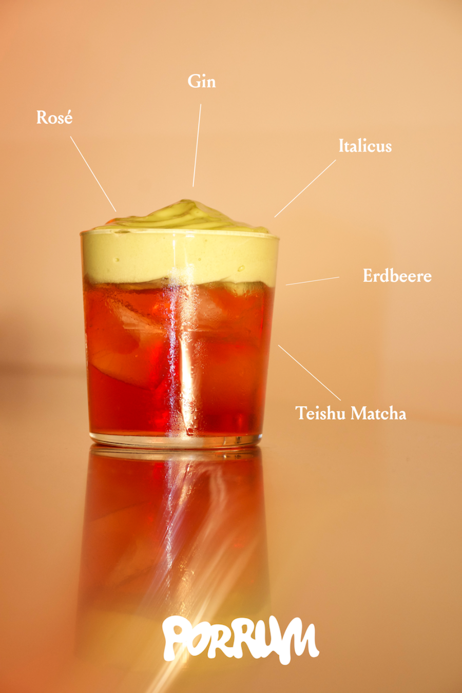 Layered red cocktail with a pale green foam top, labeled with its ingredients.