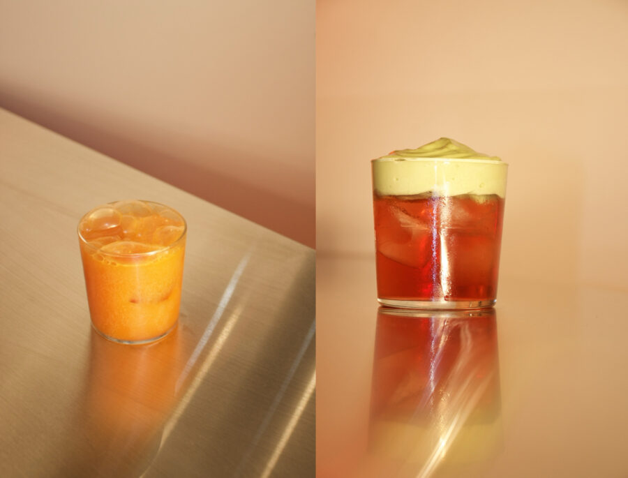 Two colorful cocktails with ice on a reflective metallic surface.